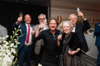 A group of people raise their glasses in celebration